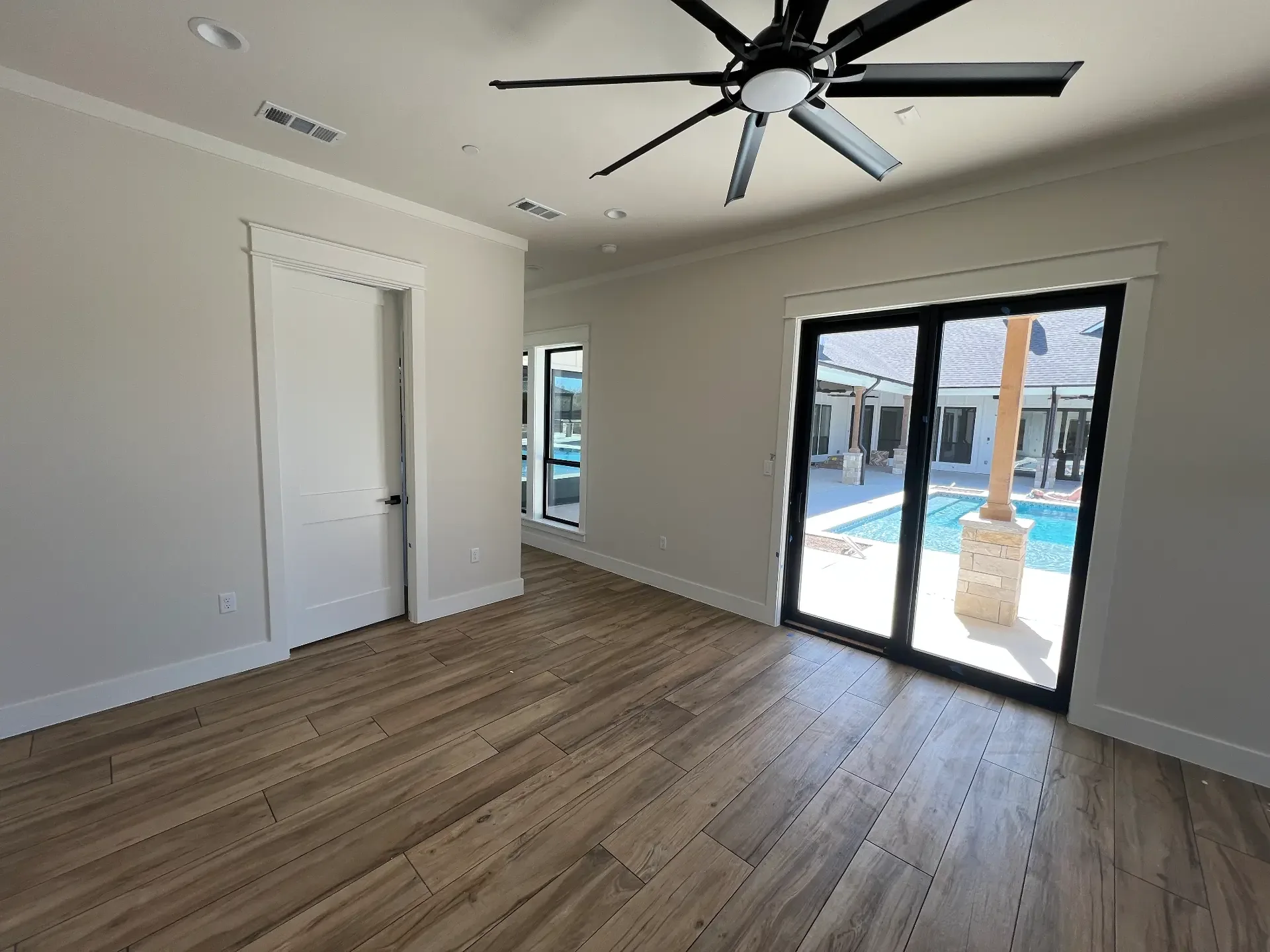 Primary bedroom with sliding glass doors opening to the pool in a Venado Construction new home build