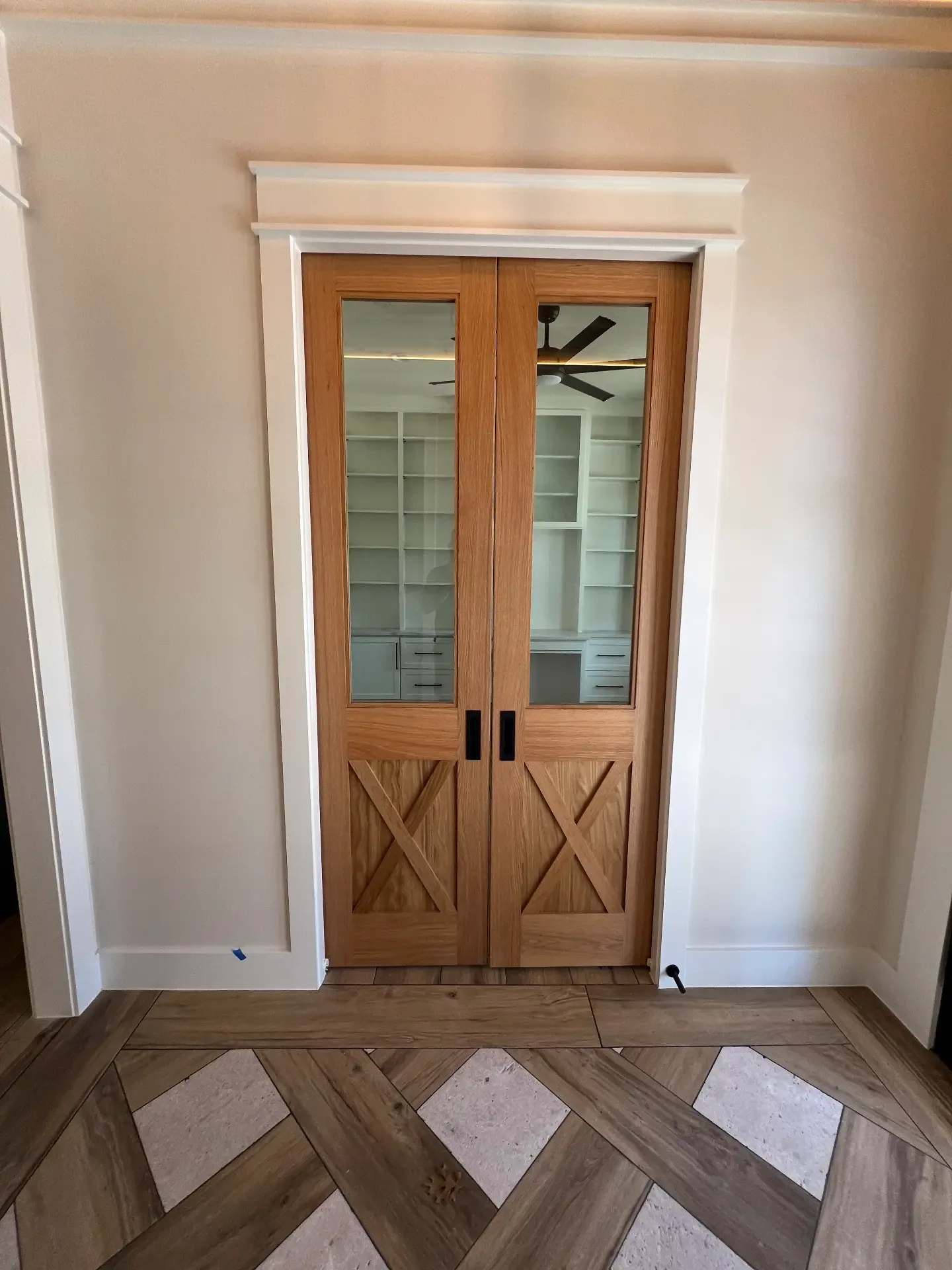 Custom light oak double barn doors in a Venado Construction new home build