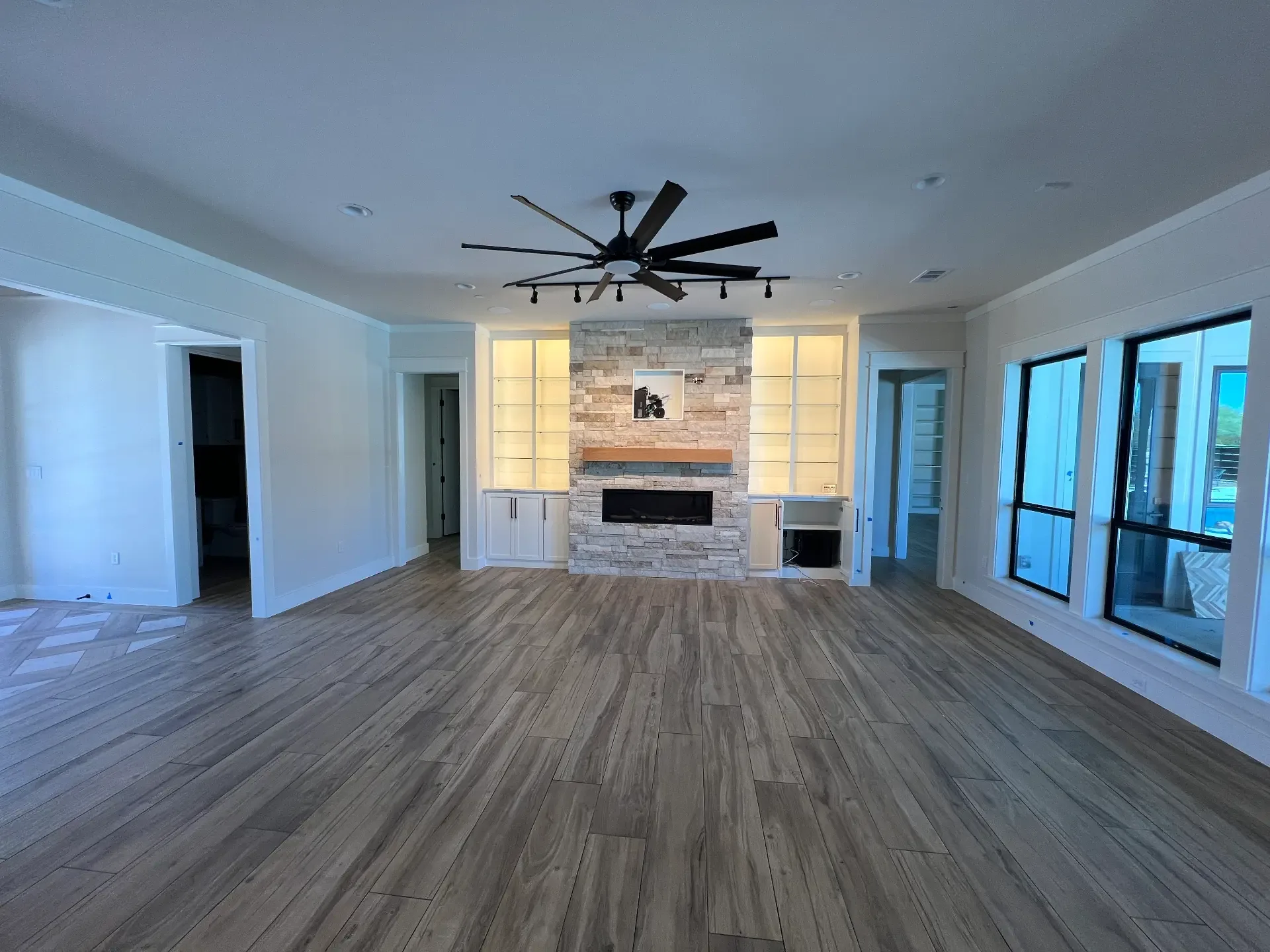 Living area of a Venado Construction new home build with a floor-to-ceiling stone fireplace