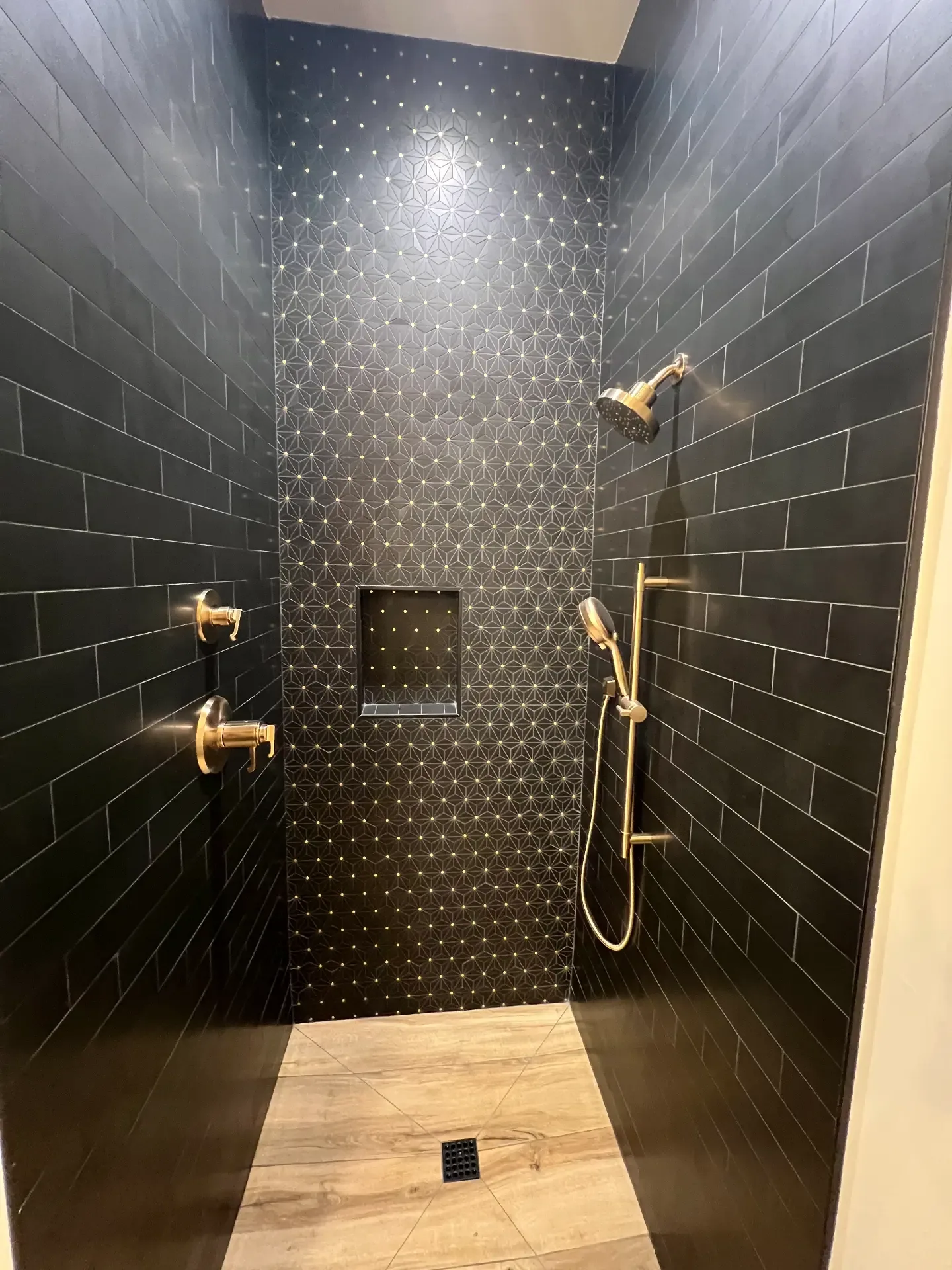 Walk-in tiled shower with black fixtures in a Venado Construction new home build