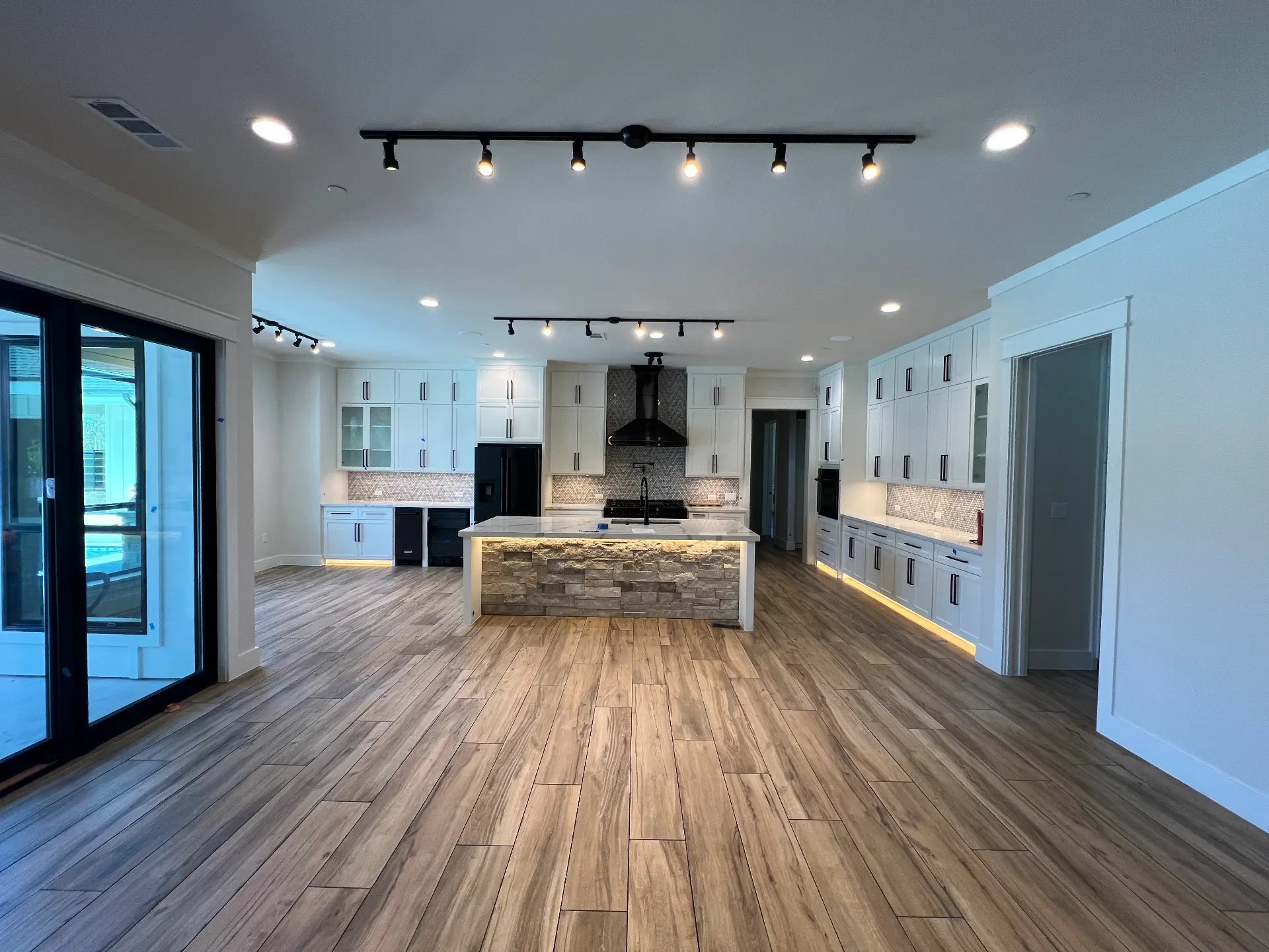 Remodeled kitchen with painted inset cabinetry, stone countertops and a large island with counter stools
